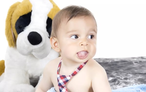 Smiling toddler with stuffed dog toy in dental office setting